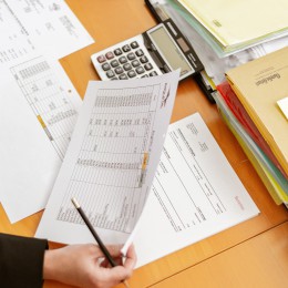 Person holding paper and using a calculator