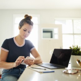 Young lady on her cell budgeting