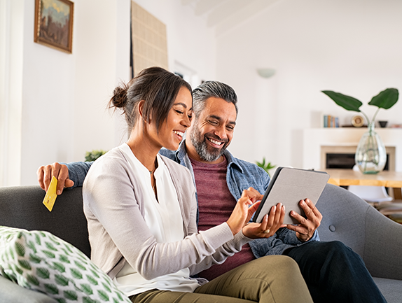 young couple sitting at home looking at computers