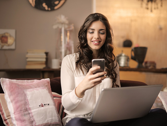 young couple sitting at home looking at computers