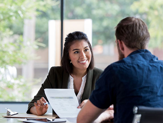 young male sitting with female banker looking at paperwork